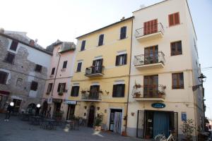 a yellow building with windows and balconies on a street at Sweet Home in San Rocco in Bolsena