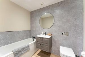 a bathroom with a sink and a mirror on the wall at Maple Apartments - Modern 2 Bed Apartment in Derby in Derby