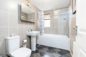 a bathroom with a toilet and a sink and a bath tub at Charming 3 Bedroom Home with Garden near Doncaster in Doncaster +42 photos