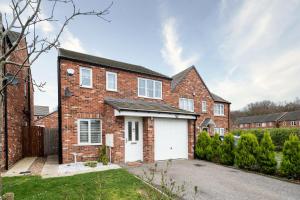 a brick house with a white garage at Charming 3 Bedroom Home with Garden near Doncaster in Doncaster