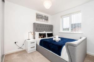 a white bedroom with a large bed with a blue blanket at Charming 3 Bedroom Home with Garden near Doncaster in Doncaster +35 photos