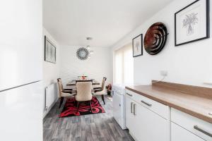a kitchen with a dining room table with a red rug at Charming 3 Bedroom Home with Garden near Doncaster in Doncaster