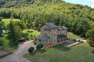 una vista aérea de una gran casa de piedra en un campo en Tenuta d'Elci - Relax e Piscina nel Bosco, en Casteldelci