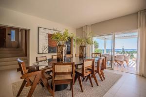 a dining room with a table and chairs with a view at Azuréenne de la Nartelle in Sainte-Maxime