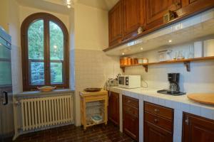 Una cocina con armarios de madera y una ventana. en Tenuta d'Elci - Relax e Piscina nel Bosco, en Casteldelci