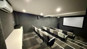 una sala conferenze con sedie bianche e schermo di The Bolton Rosebank a Johannesburg Altre 14 foto