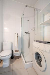 a bathroom with a toilet and a washing machine at Silver Coast by Seareen in Armação de Pêra