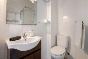 a white bathroom with a sink and a toilet at Silver Coast by Seareen in Armação de Pêra +9 photos