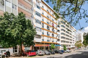 an apartment building with cars parked in a parking lot at Silver Coast by Seareen in Armação de Pêra