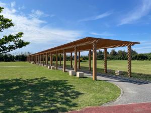 a pavilion with benches under a roof in a park at muniyuitsu 宮古島 spa&park in Miyako-jima