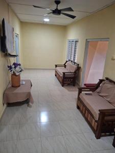 a living room with two beds and a ceiling fan at SKK Guest House in Urumpirai