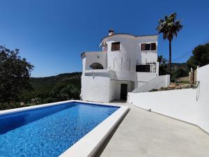 a villa with a swimming pool in front of a house at Villa with stunning sea views in Alcossebre