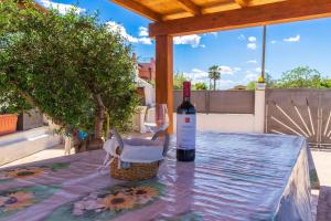 a bottle of wine and a glass on a table at Villa Nova in Àrbatax