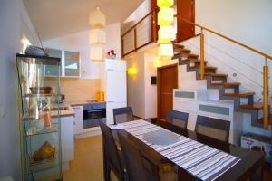 a kitchen with a dining room table and a staircase at Apartman blizu plaže u Betini in Betina