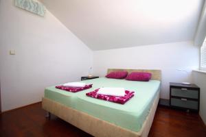 a bedroom with a large bed with red pillows at Apartman blizu plaže u Betini in Betina