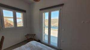 a bedroom with a bed and a large window at Vista del sole Kythnos in Kithnos