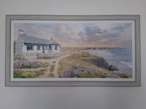 a painting of a house next to the ocean at Barbican Paignton in Paignton