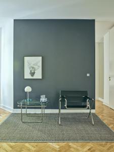 ein Wohnzimmer mit einem Stuhl und einem Tisch in der Unterkunft Design Apartments am Römerturm in Köln