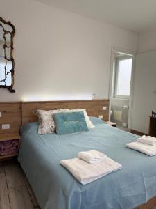 a bedroom with a blue bed with towels on it at Pirandello Rooms in Verona +13 photos