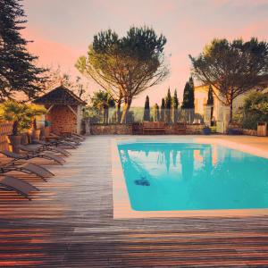 een zwembad met stoelen op een houten terras bij Maison Lotus in Saint-Martial-de-Valette