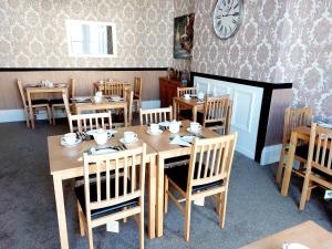 a dining room with wooden tables and chairs and a clock at The Patricia in Torquay