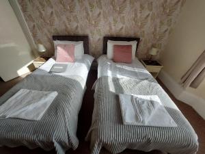 two twin beds in a room with towels on them at The Patricia in Torquay +34 photos