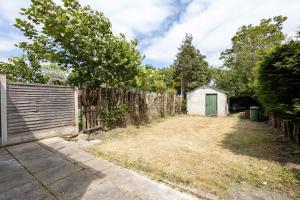 a backyard with a fence and a shed at Spacious & Bright 3 Bedroom House in St Helens in Burtonwood +19 photos