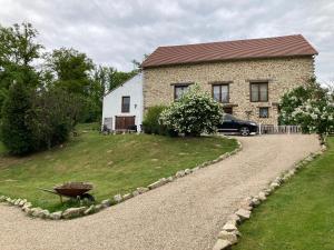 a house with a wheelbarrow in front of a driveway at La Grange in Naillat