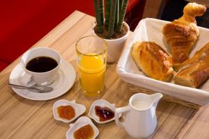 a table with a breakfast of bread and coffee and orange juice at Hotel Auguste in Paris