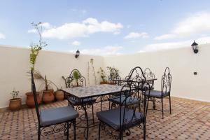 un patio con mesa, sillas y plantas en Riad Taryana, en Fez