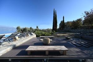 a patio with chairs and a wooden table and benches at Rosmarino Villa Galaxidi in Galaxidhion