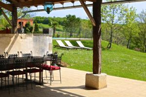 a table and chairs under a pavilion with a lawn at Maison Orchidée in Saint-Martial-de-Valette