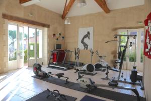 a gym with several treadmills and exercise bikes at Maison Orchidée in Saint-Martial-de-Valette