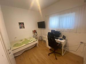 ein Schlafzimmer mit einem Bett und einem Schreibtisch mit einem Computer in der Unterkunft Big quiet Cottage in centre Raanana in Ra‘ananna