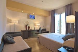 a hotel room with a bed and a couch at Zen Hotel Versilia in Marina di Pietrasanta +37 photos