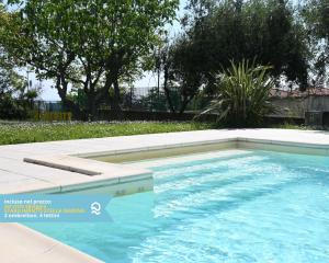 a swimming pool with blue water in a yard at VIVA1 - Numana, nuovo pentalocale in villa con piscina in Numana