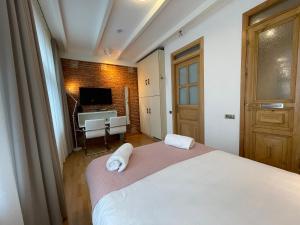 a bedroom with a bed and a desk and a television at Amsterdam-bnb in Amsterdam