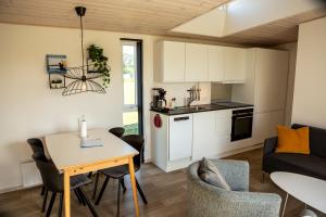 a kitchen and living room with a table and chairs at DCU-Camping Hornbæk in Hornbæk