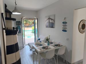 ein weißes Esszimmer mit einem weißen Tisch und Stühlen in der Unterkunft OasiMareBlu in Marina di Ragusa