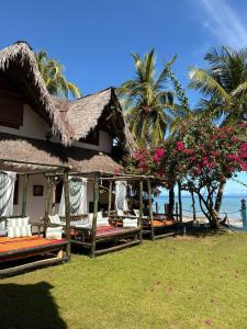 a resort with beds and flowers in front of the ocean at Villa Valiha Boutique Hotel in Madirokely