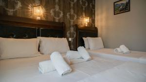 two beds with white pillows sitting next to each other at Toti Boutique Rooms in Kalabaka