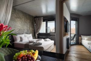 a hotel room with two beds and a table of fruit at Onyx Luxury in Sárvár