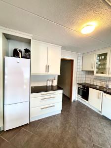 a kitchen with white cabinets and a white refrigerator at Faleide Grandview in Stryn +15 photos