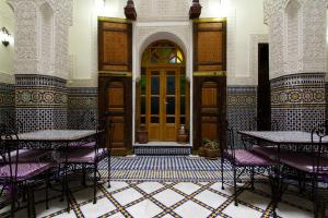 a room with tables and chairs and a door at Riad Taryana in Fez