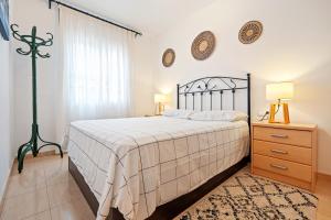 a bedroom with a bed and a dresser and a window at Hauzify I Casa Ribera in Cunit +10 photos