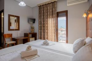 a hotel room with two beds and a window at Toti Boutique Rooms in Kalabaka
