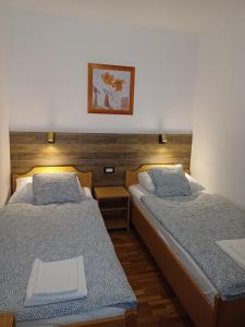 a room with two beds and a picture on the wall at Apartman BoloB in Baška