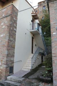 Un edificio blanco con escaleras al lado de un edificio de ladrillo. en Lo ZIO EZIO, en Montepulciano
