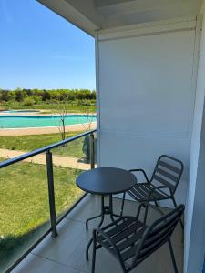 a table and chairs on a balcony with a view of a pool at Gabriela Blaxy Apartamente in Olimp +6 photos