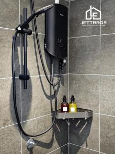a shower head with a hose attached to a wall at JettBros De' milota at Midas Seri Alam Johor Bahru in Masai